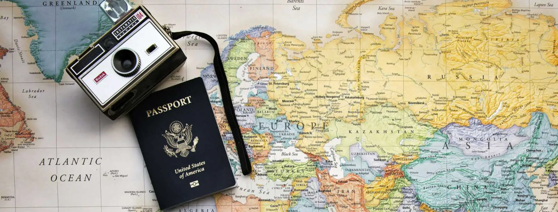 map with passport and camera on top