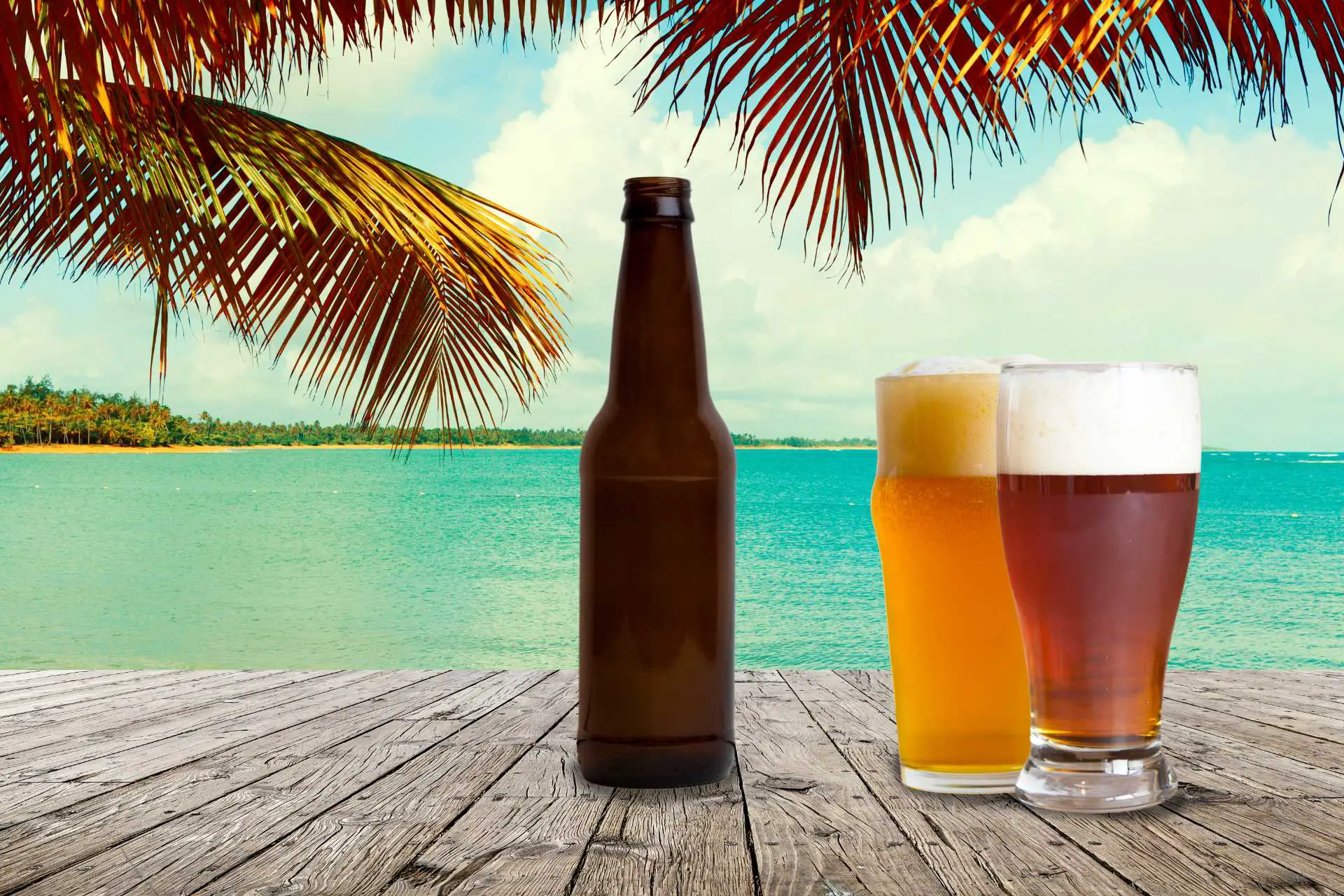 glasses and bottle of beer with beach background