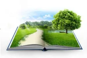 An opened book with grass and a tree popping out
