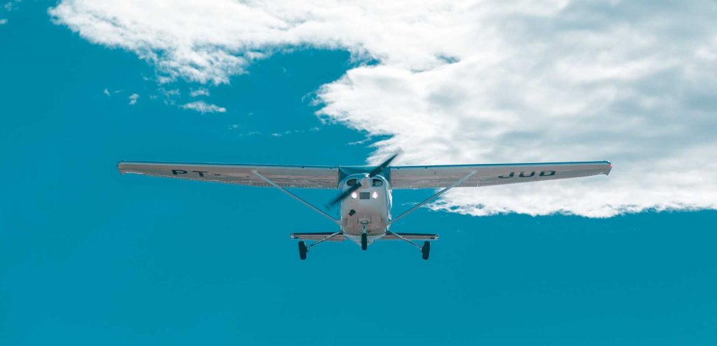 small plane flying amidst blue skies